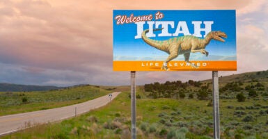 A sign by the side of a remote highway welcomes people to the state of Utah.