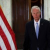 Sen. Ron Johnson strolls through the U.S. Capitol past an American flag.