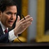 Secretary of State Marco Rubio testifies before members of Congress in a dark suit and tie.