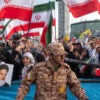 Iranians wave the country's flags during a ceremony commemorating the anniversary of the death of Iranian President Ebrahim Raisi on May 15 in Tehran, Iran.