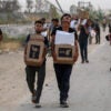 People carry relief supplies from the Gaza Humanitarian Foundation.