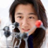 An Asian American high school student looks closely at a model of a molecule