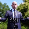 White House Deputy Chief of Staff Stephen Miller addresses media outdoors, arms outstretched.