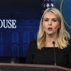 Karoline Leavitt, dressed in a dark outfit, speaks at a White House press briefing.